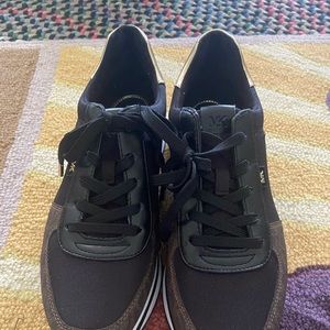 Michael Knor black and gold sneakers. Monique track black and gold.